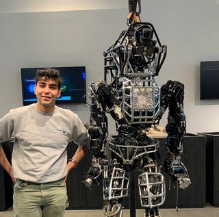 Portrait of Akshay Jaitly standing beside a humanoid robot